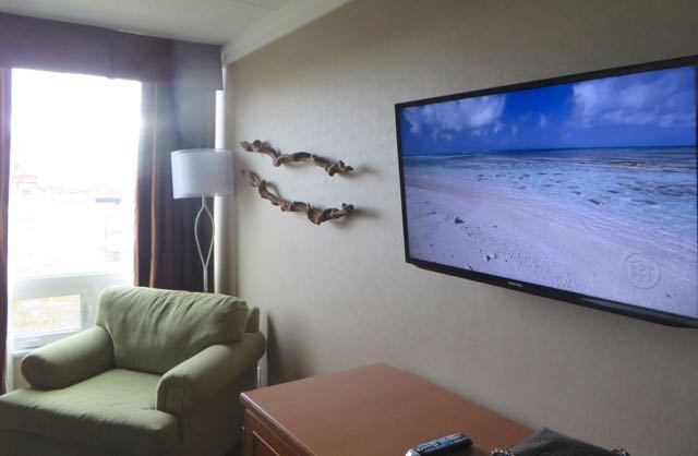 Across from the bed is a large flat screen TV that is set to a channel playing soothing music while scrolling though relaxing scenes.