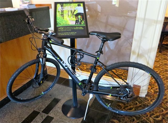 While waiting for the shuttle to return me to the airport I noticed this bike by the front desk. The green sign explains that the hotlel has a variety of bikes available for their guests to use as no charge.