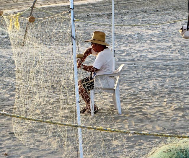 This fisherman works day after day patiently repairing his nets. A;sways fun to see him bring them in and see what the ocean shared with him.