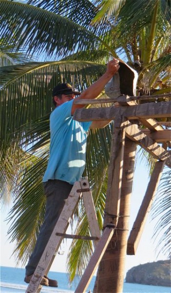 Lupe then used a small plastic container to pour the concrete down the tube. every now and then he would tap the cardborad tube with a screwdriver in an effort to get the concrete to move down the tube.